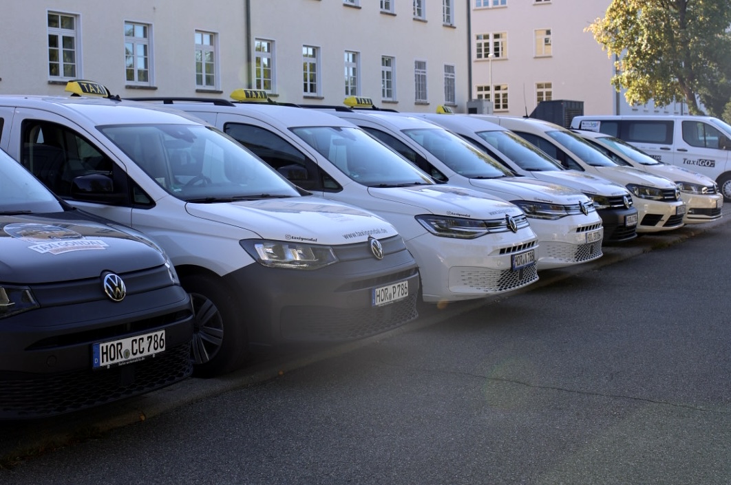 Die Flotte von Taxi Gondal – zahlreiche Taxis und Großraumfahrzeuge in einer Reihe am Betriebshof