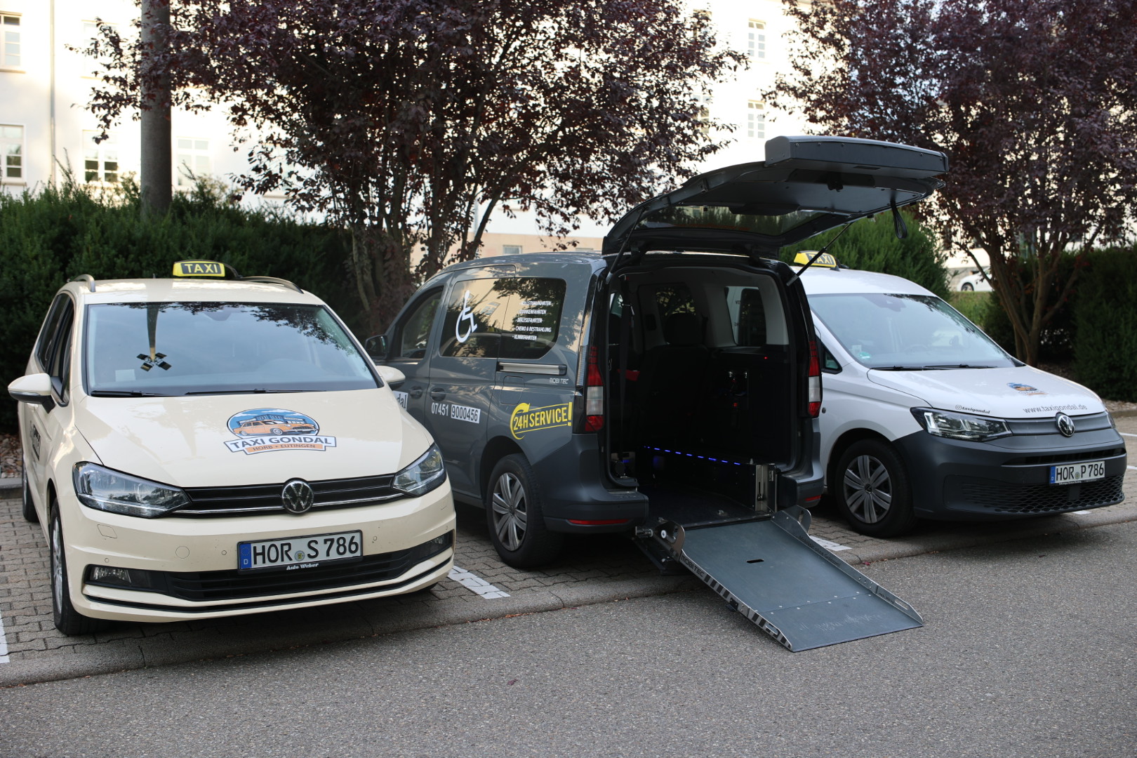 Drei Taxis von Taxi Gondal in Horb: beiger Touran, rollstuhlgerechter Caddy mit Rampe und weißer Caddy